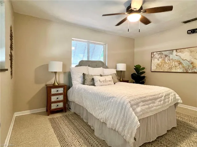 Primary Bedroom with baseboards, light colored carpet, and a ceiling fan