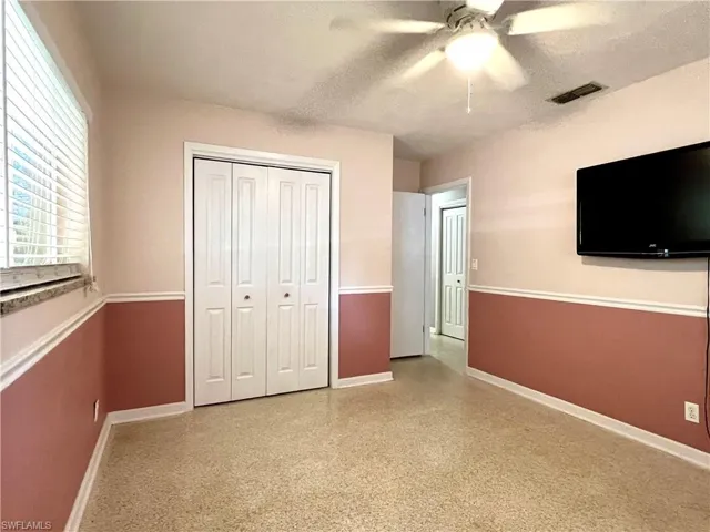 Unfurnished bedroom with baseboards, a closet, a textured ceiling, and a ceiling fan