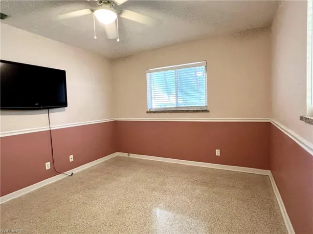 Spare room with a ceiling fan, a textured ceiling, and baseboards