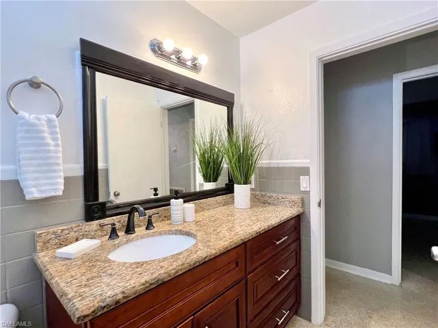 Hall Bathroom with vanity and tile walls