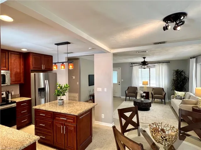 Kitchen featuring appliances with stainless steel finishes, dark brown cabinets, open floor plan, ceiling fan, and recessed lighting