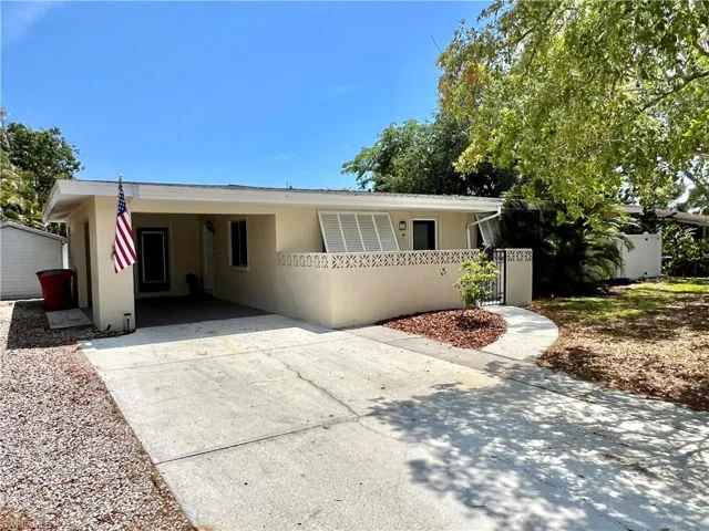 Single story home with concrete driveway, stucco siding, a carport, and fence