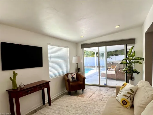 Florida room/dem featuring baseboards, lofted ceiling, light tile patterned flooring, and recessed lighting