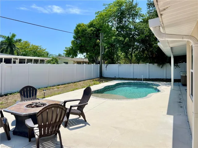 View of pool featuring a patio, a fire pit, and a fenced backyard
