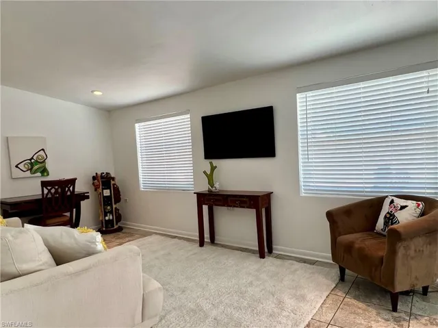 Florida room/Den with healthy amount of natural light, baseboards, and light tile patterned floors