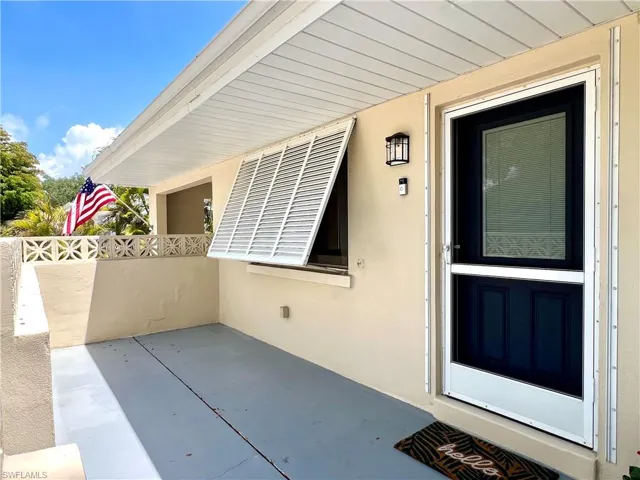 View of exterior entry featuring stucco siding and a patio area