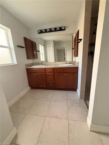 Full bathroom with double vanity and tiled shower