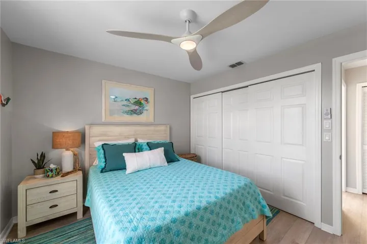 Bedroom featuring light wood-finish flooring and a contemporary ceiling fan with integrated lighting