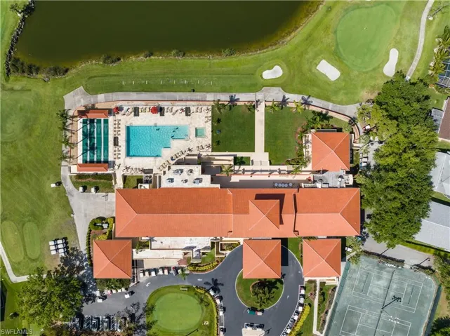 Aerial view showcasing the expansive property including clubhouse, swimming pool, spa, tennis courts, and golf course with putting greens and sand traps