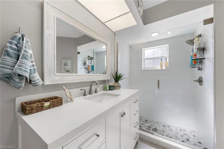 Modern bathroom featuring a single vanity with a white countertop, undermount sink, and brushed nickel faucet