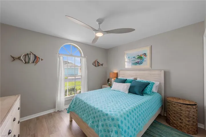 Bedroom featuring a light gray wall color, a contemporary ceiling fan, and wood-finish flooring
