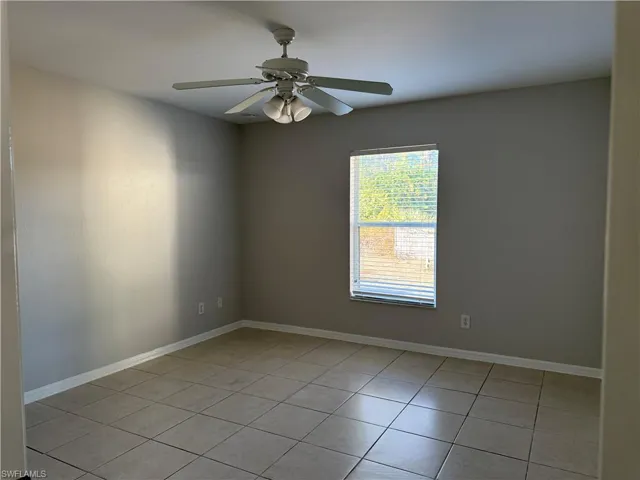 Masterbedroom with a ceiling fan and light tile patterned floors