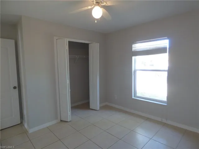 Guest Bedroom featuring ceiling fan, a closet, and light tile patterned flooring