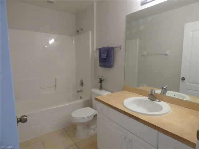 Guest bathroom featuring vanity, shower / bathtub combination, and light tile patterned floors