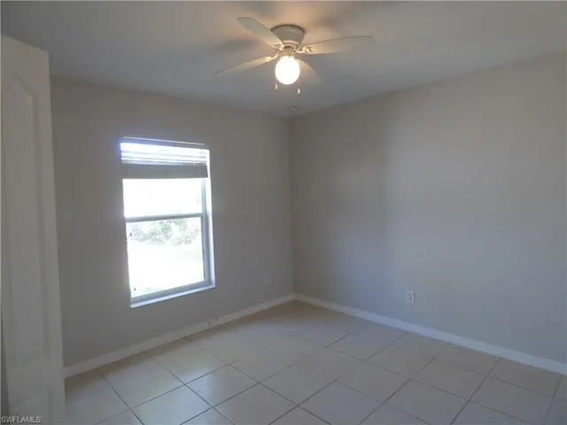 Guest bedroom featuring ceiling fan and light tile patterned floors