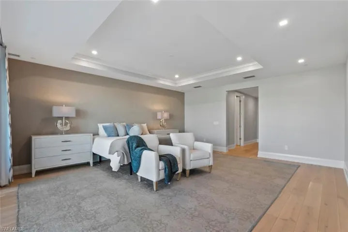 Master Bedroom featuring light wood-style floors, recessed lighting, and a raised ceiling