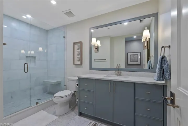 Full bathroom with vanity, a stall shower, and recessed lighting