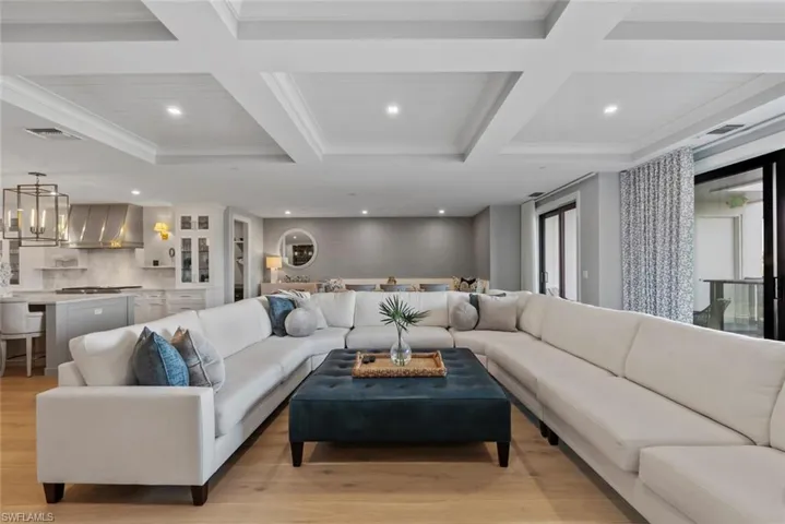 Living area with beamed ceiling, recessed lighting, coffered ceiling, and light wood-style floors