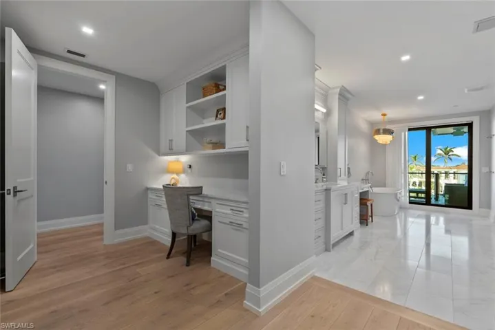 Inside Master Office area with built in study area, recessed lighting, and light wood-type flooring