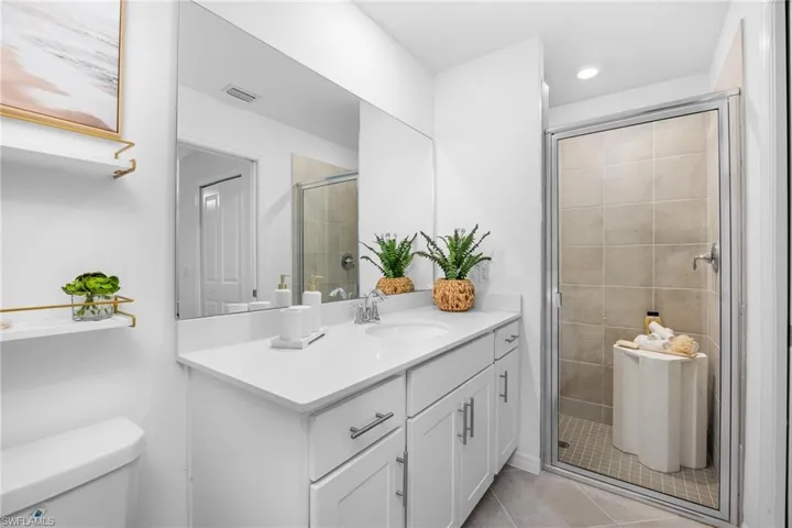 Bathroom with vanity, tile patterned flooring, a shower stall, and recessed lighting