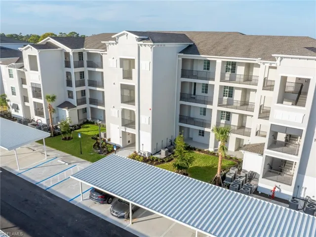 View of apartment building / complex with uncovered parking