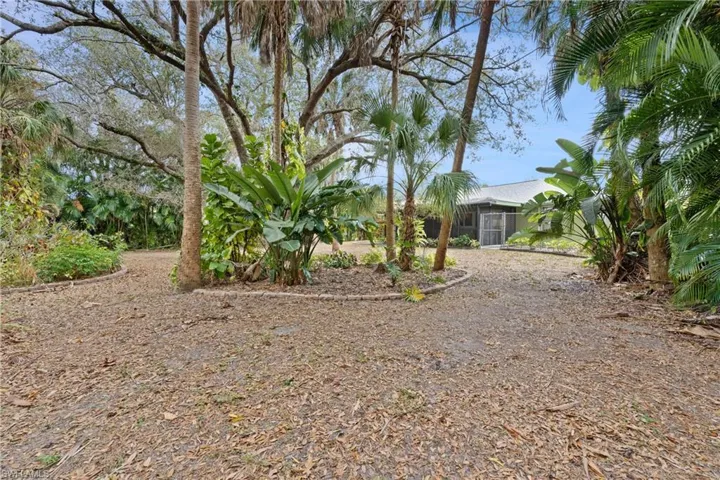 View of large yard featuring a sunroom
