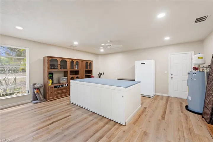 Office space featuring ceiling fan, light wood-style flooring, recessed lighting, and new electric water heater, 2 outside entrances