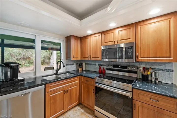 Kitchen featuring stainless steel appliances, wood finish cabinets, ornamental molding