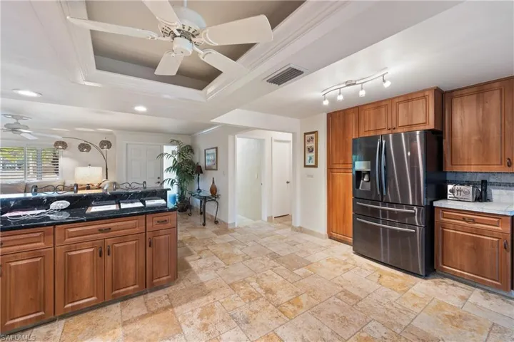 Open Kitchen with wood finish cabinetry, ceiling fan, stainless steel refrigerator with ice dispenser, crown molding, and recessed lighting