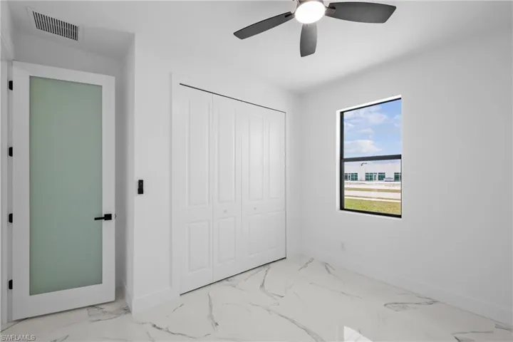 Unfurnished bedroom with baseboards, marble finish floor, visible vents, a ceiling fan, and a closet