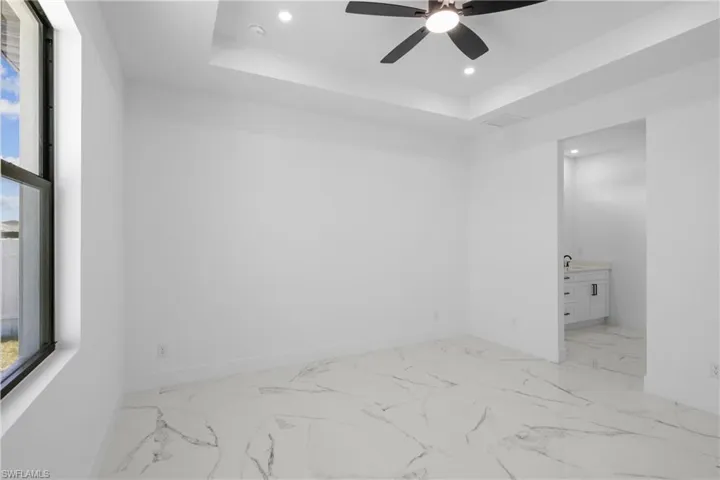 Spare room featuring baseboards, ceiling fan, recessed lighting, and a raised ceiling