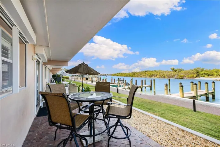 View of patio / terrace with outdoor dining area, a water view, and a boat dock