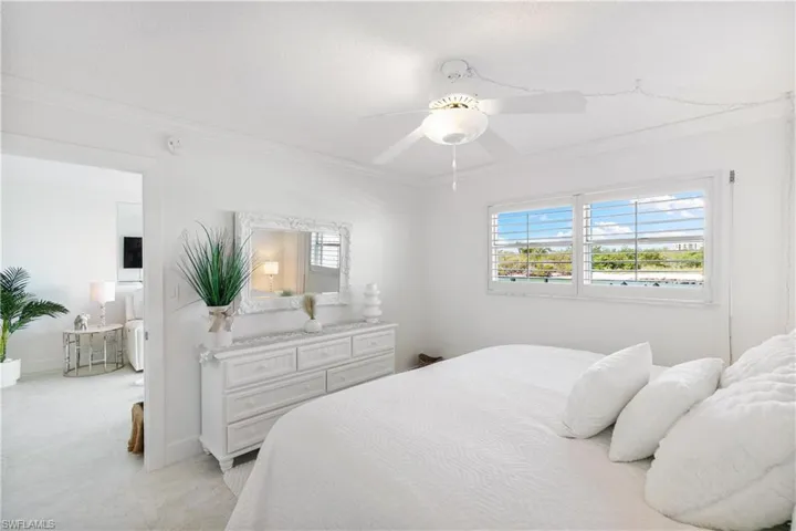 Bedroom featuring multiple windows, ceiling fan, and crown molding