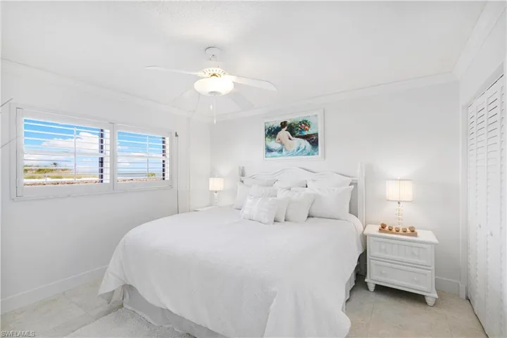 Bedroom with crown molding, a ceiling fan, and light tile patterned floors