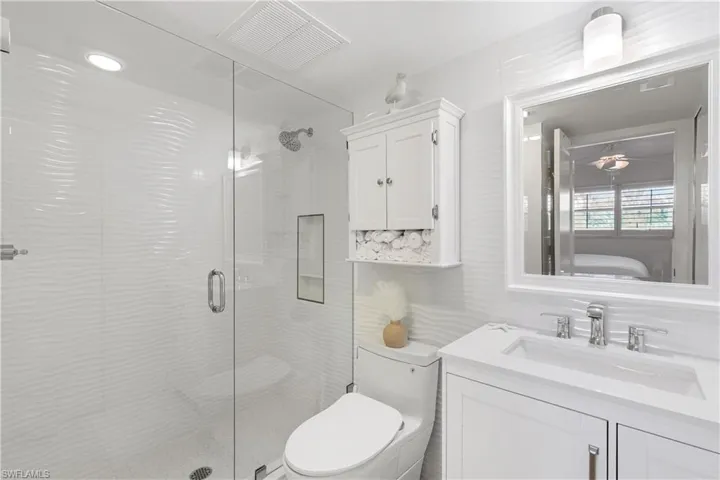 Full bath with vanity, a stall shower, and ensuite bath
