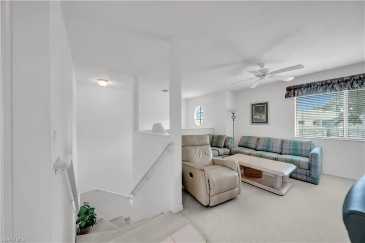 Living room featuring carpet flooring and a ceiling fan