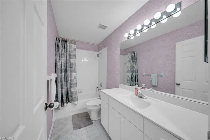 Full bathroom with shower / bath combo, vanity, and light tile patterned floors