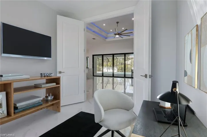 Office area with ceiling fan and a raised ceiling