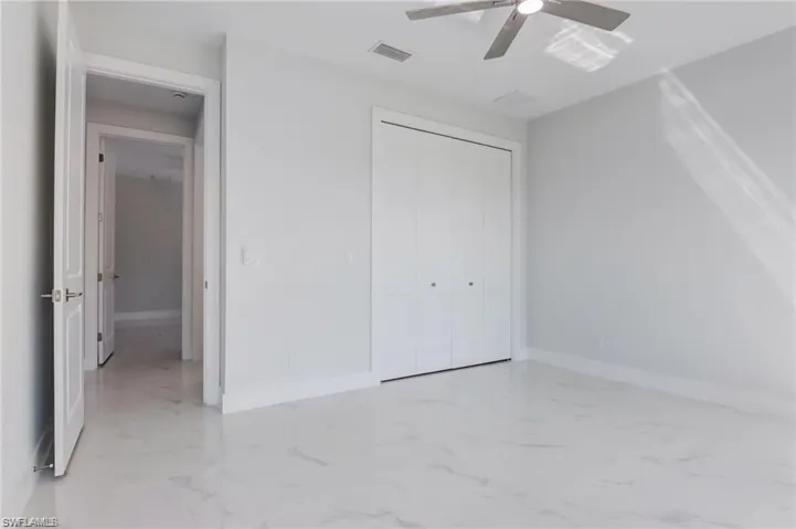 Unfurnished bedroom featuring ceiling fan and a closet