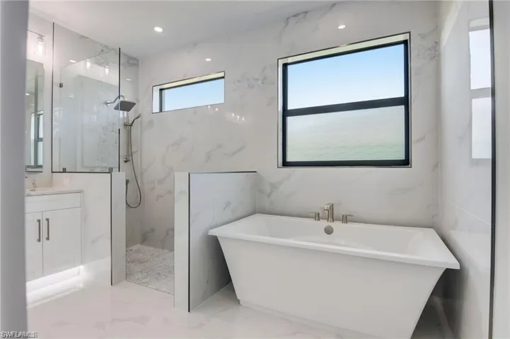 Bathroom featuring vanity and shower with separate bathtub
