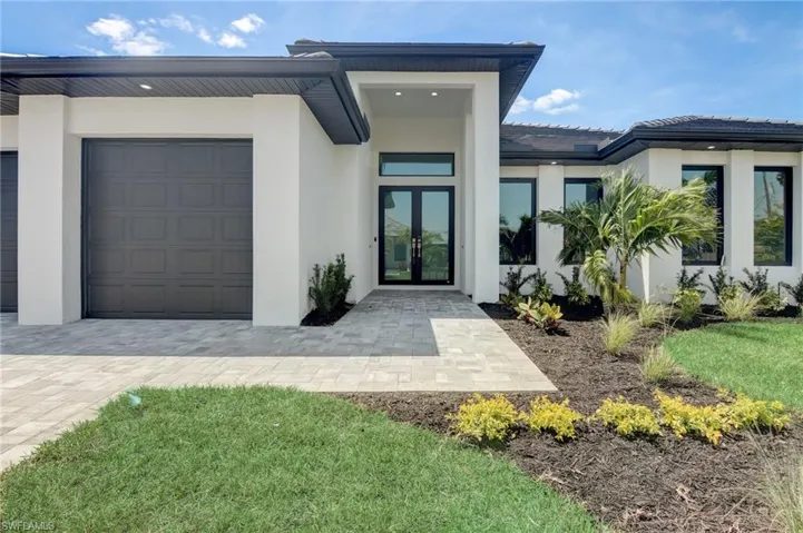 View of exterior entry with french doors and a garage