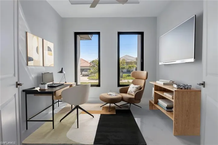 Home office featuring ceiling fan and concrete floors