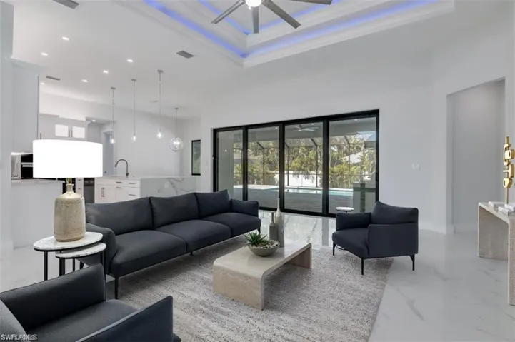 Living room with a towering ceiling, ceiling fan, and sink