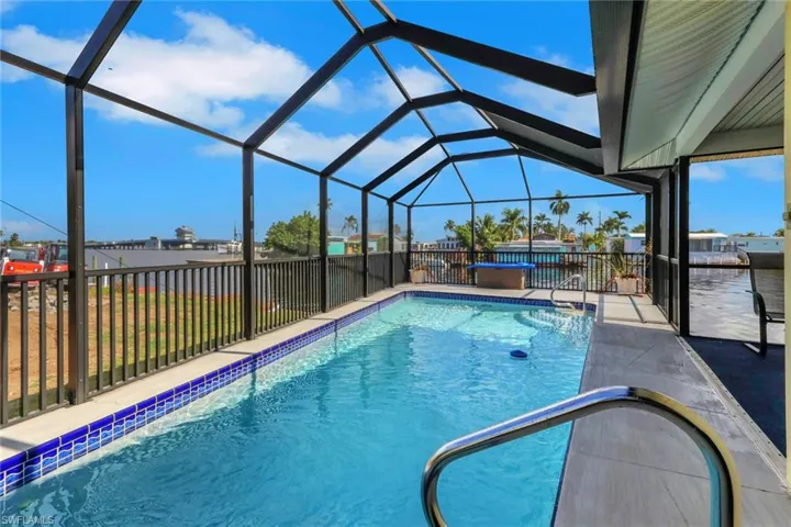 Glistening pool facing southeast with a screened pool enclosure.