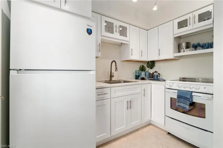 Modern white cabinets, new appliances and white quartz counter tops, with gray veins running through for character.
