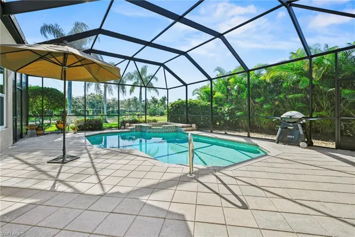 View of swimming pool with a sunroom, a lanai, grilling area, a pool with connected hot tub, and a patio