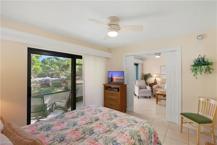 Bedroom featuring access to outside, light tile patterned floors, and a ceiling fan