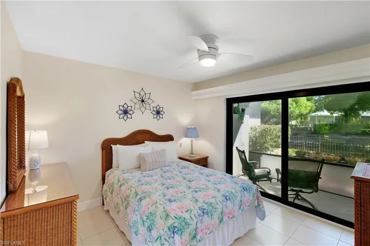 Bedroom with light tile patterned floors, access to outside, and a ceiling fan