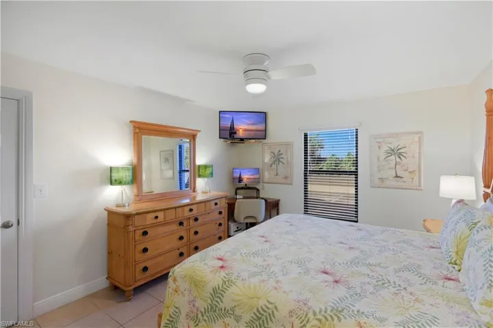 Bedroom with light tile patterned flooring and a ceiling fan