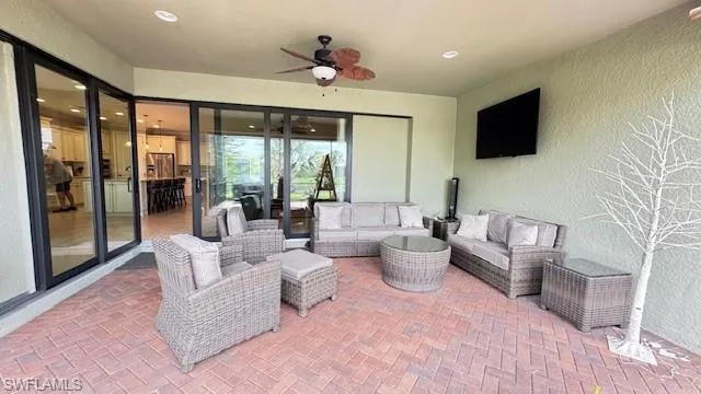 View of lanai with outdoor lounge area, ceiling fan, wall mounted TV
